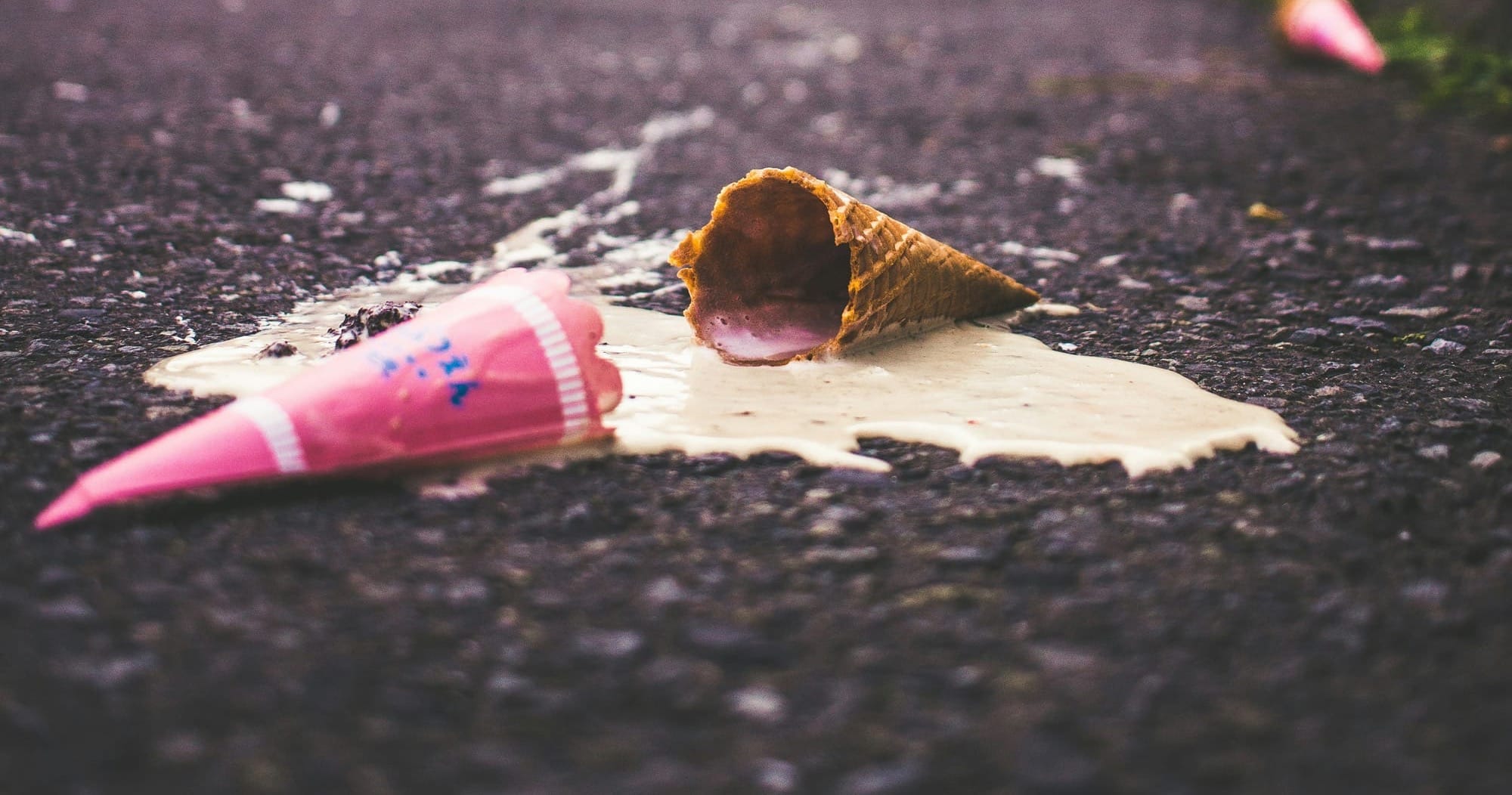 Melted ice cream cone spilled on a road.